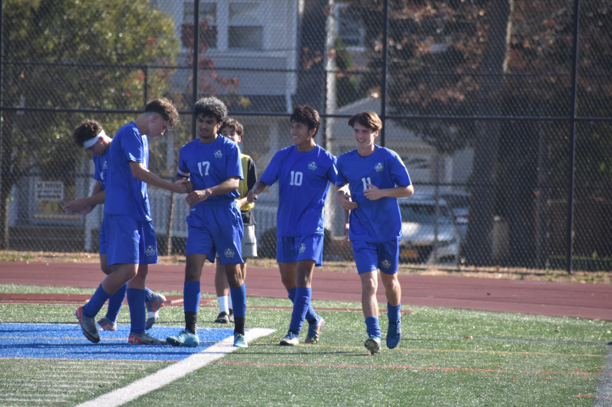 Varsity Soccer players celebrate together after Usman Iqbal scores. (Source by Mia Campuzano)